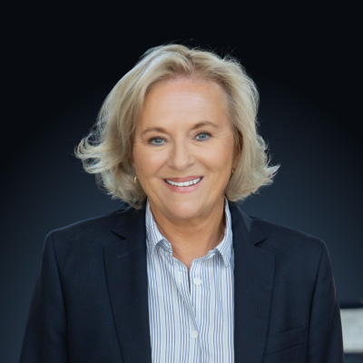 Smiling woman with a dark jacket and white shirt with thin blue stripes