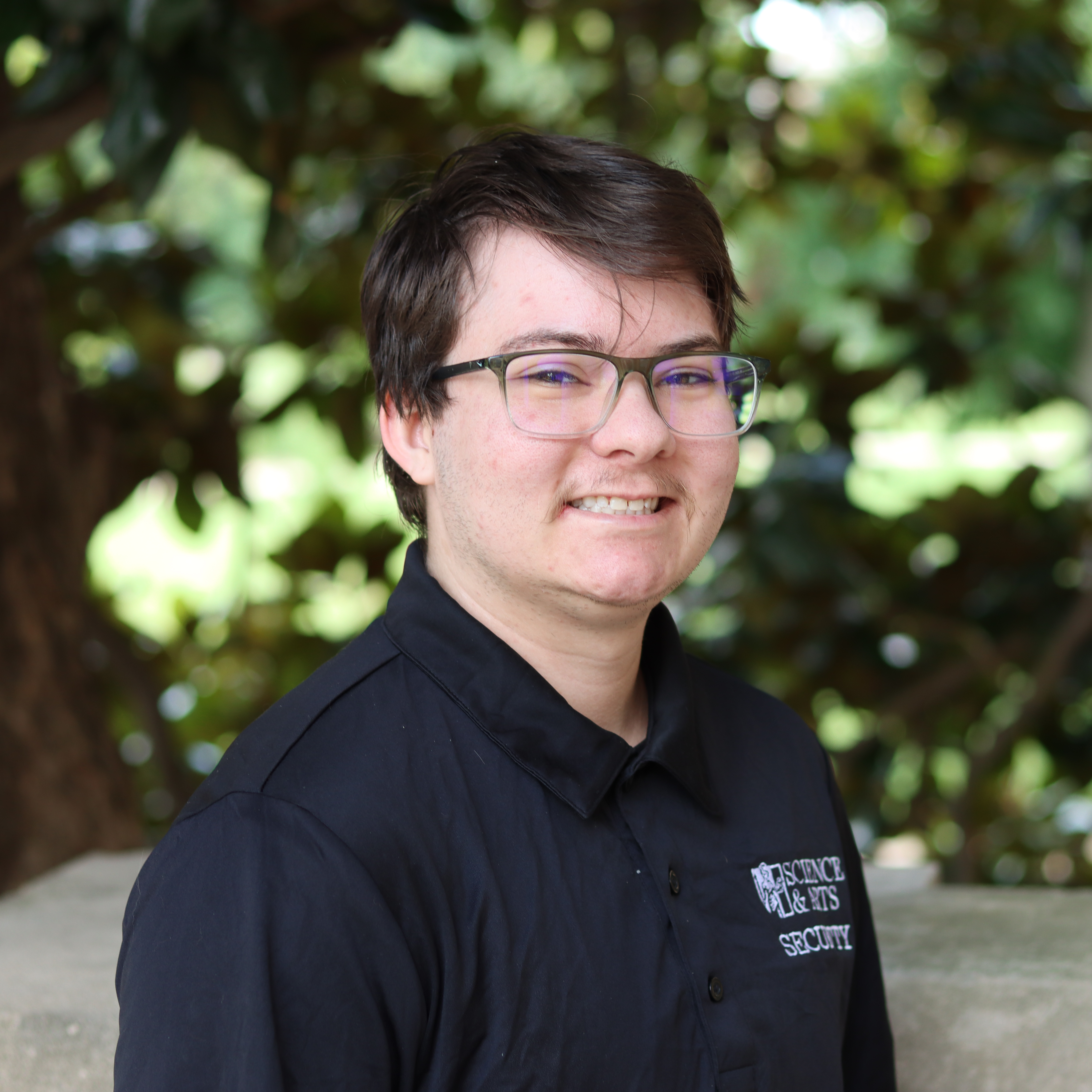 Man smiling in black shirt and glasses