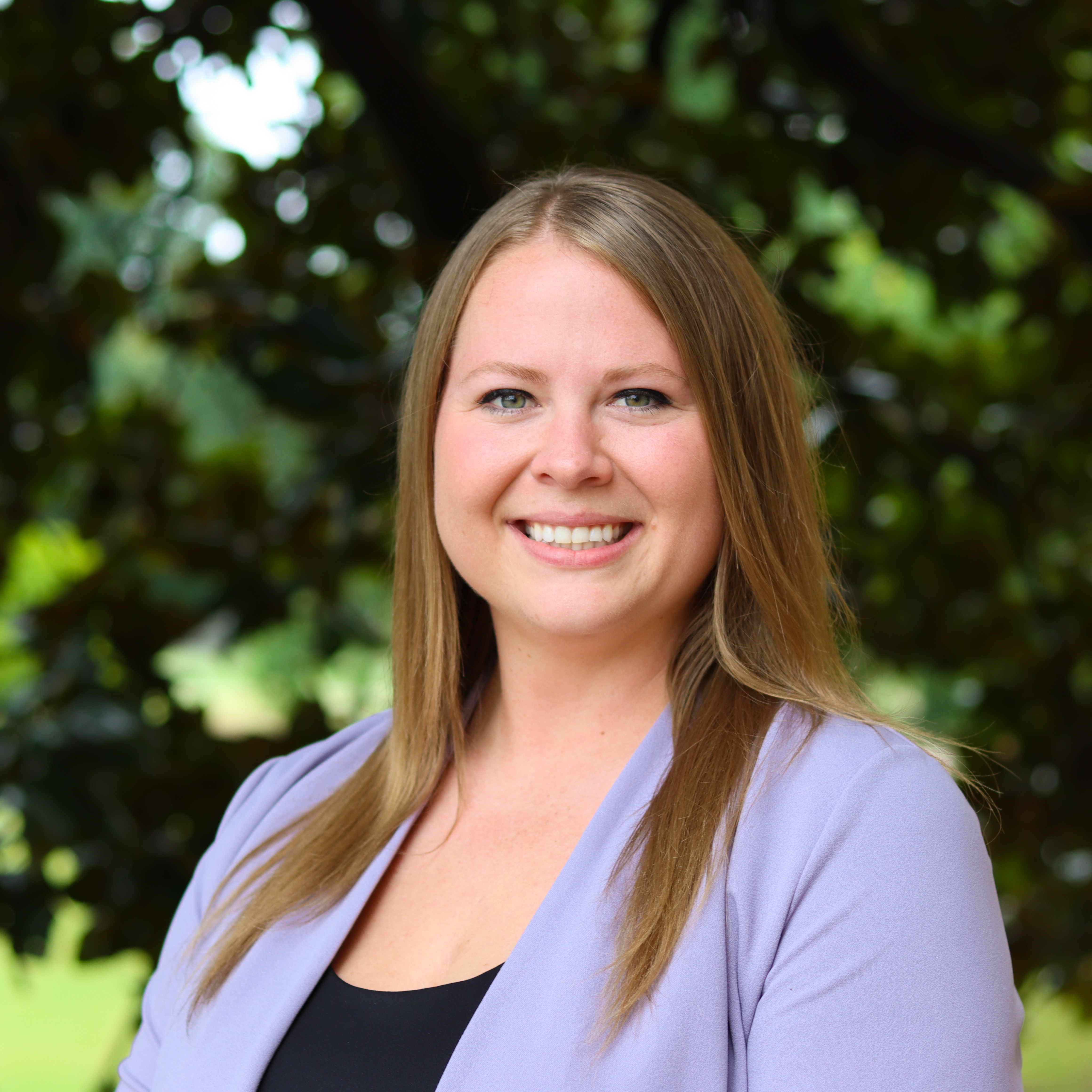 Smiling woman in black shirt with purple cardigan